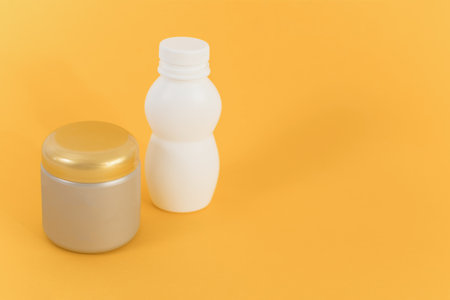 Mockups of two unbranded bottle for branding and label on orange background.の写真素材