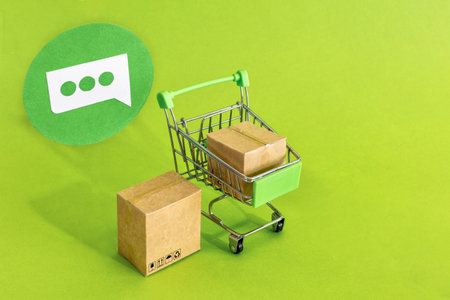 Cardboard boxes or paper boxes in shopping cart on green background. Online shopping and delivery service concept.の写真素材