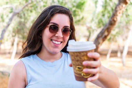 Happy girl offering a cup of coffee.