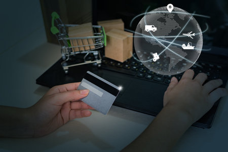 Transportation and intelligent global logistics network, female hand holding a credit card. Digital composite image.の写真素材