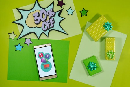 Online gift purchase, discount text. Comic style text. On green background. Business concept. top view.の写真素材