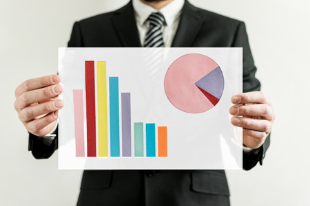 Young executive in a suit shows with his hands a picture with statistics.の写真素材