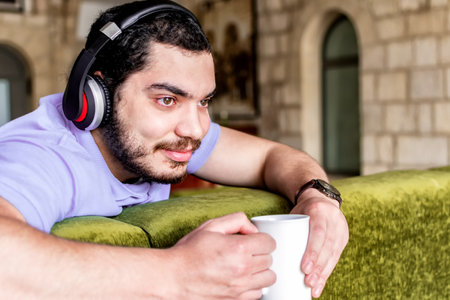Side view portrait of a satisfied man enjoying coffee at home.の写真素材