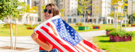 Patriotic holiday. Happy girl with US flag.の写真素材