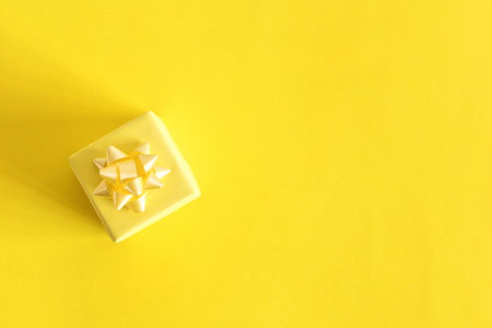 Top view of small yellow gift. Celebration concept. On pastel yellow background.の写真素材