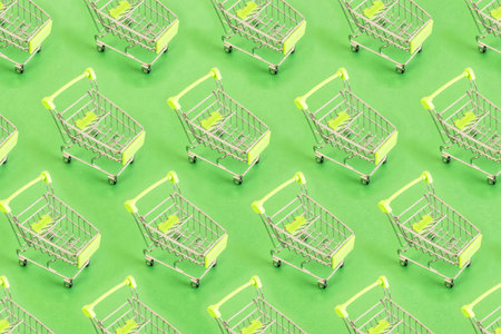 Top view of pattern Empty shopping cart on green background, buy and sell concept.