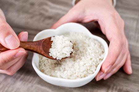 Close up of wooden spoon with rice grains.の写真素材