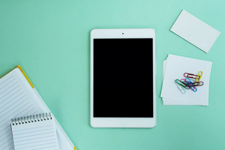 tablet similar to i pad style, with creative office work tools on light blue background, on top...