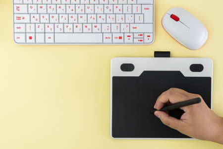 graphic tablet, keyboard and mouse, on yellow background. zenith view photo.の写真素材