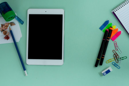 tablet similar to i pad style, with creative office work tools on light blue background, on top...