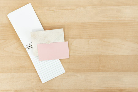 Wedding invitation mockup card with paper and envelope, on wooden desk.