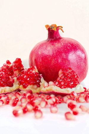 Ripe pomegranate fruit isolated on white background cutout.