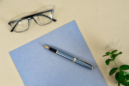 Business concept. Paper rustic sheet, pen and eyeglasses on beige background.の写真素材