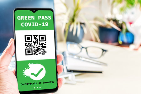 Vaccinated person using digital health passport app in mobile phone for travel during covid-19 pandemic. Digital green certificate.の写真素材