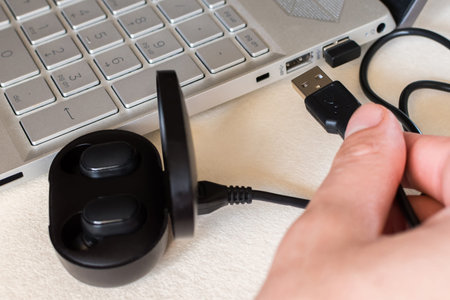 USB charge cable and wireless earphones. Wireless headset connection on laptop.