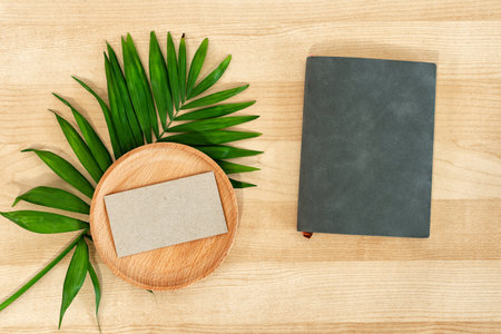 Blank business card, notepad on wooden work desk.の写真素材