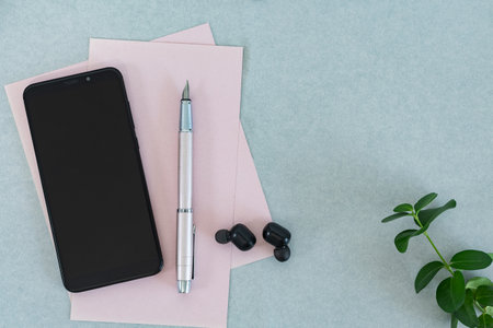 Mock up pink business memo and blank mobile screen on light blue table.の写真素材