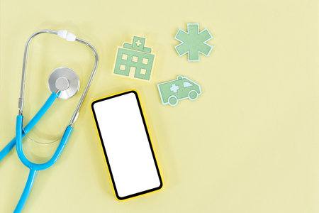 Tablet with blank screen and stethoscope, on yellow background. top view.の写真素材