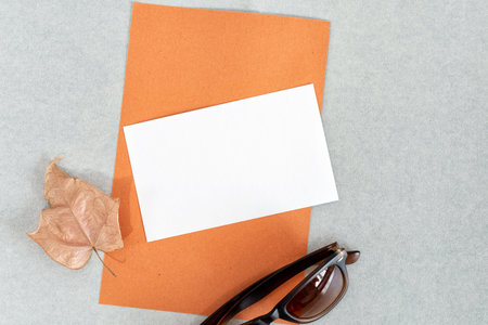 Invitation or greeting card mockup with dry leaf decorations.の写真素材