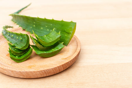 Fresh aloe vera leaves and slices of aloe vera on a wooden background.の写真素材