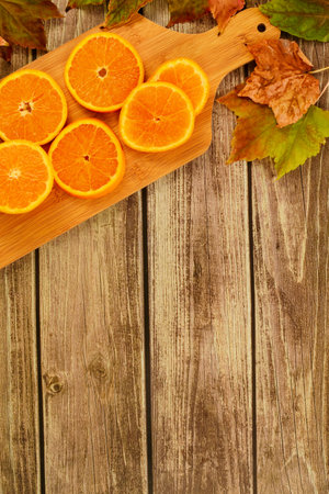 collection beautiful colorful autumn leaves and orange slices on wooden background. copy space text.の写真素材