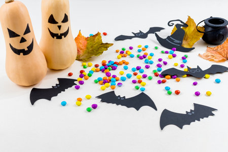 Halloween, pumpkins, bat silhouettes, colored sprinkles, cauldron, witch hat, on white background. Select focus.の写真素材