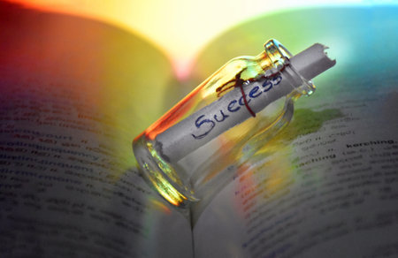 A closeup shot of a bottle with the word success on an open book