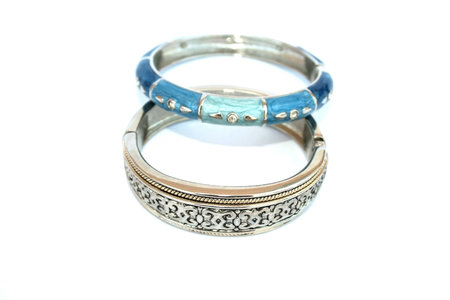 Silvery bracelet with ornament and blue and cyan bracelet with drops on the white.