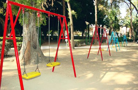 Swing chairs in playing garden.の写真素材
