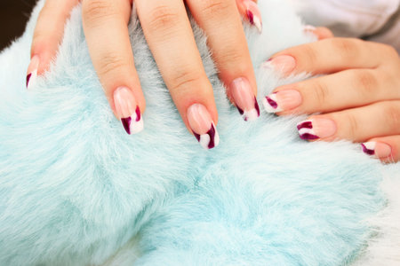 Woman hands with nail art on blue fur background.の写真素材