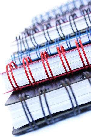 Stack of colorful copybooks isolated on white background.の写真素材
