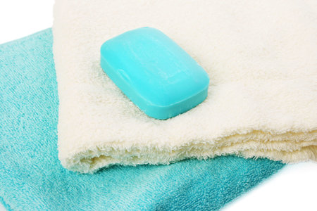 Towels and soap on white background.