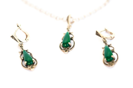 Necklace and earrings wirh green stones isolated on white background.の写真素材
