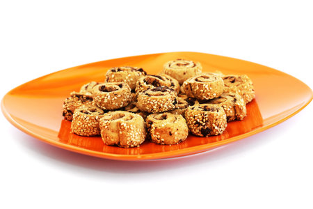 Rusks with sesame seeds and olives on orange plate isolated on white background.の写真素材