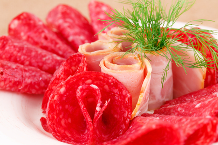 Salami and bacon on plate closeup image.の写真素材