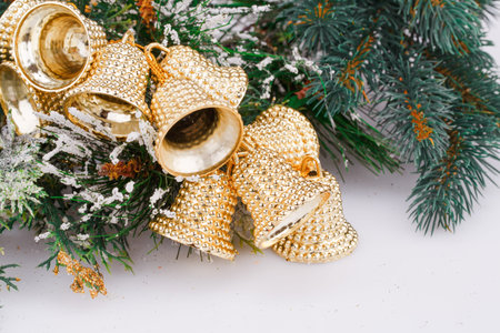Christmas bells and fir-tree branch on gray background.の写真素材