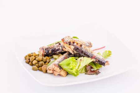 Fish, peppers, lettuce  and capers on white plate.の写真素材