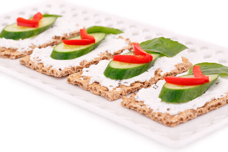Cracker with fresh vegetables and cream on plate.の写真素材