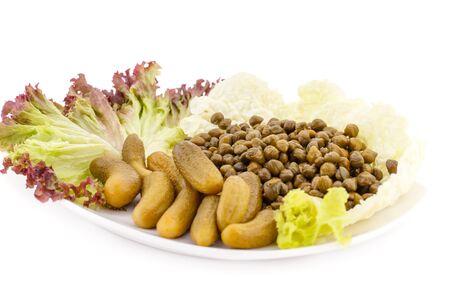 Marinated pickled cucumbers, capers and lettuce on plate.の写真素材
