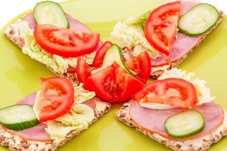 Sandwiches with fresh vegetables and ham on plate.の写真素材