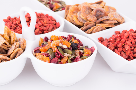 Dried fruits, berries and seeds in bowls closeup picture.の写真素材