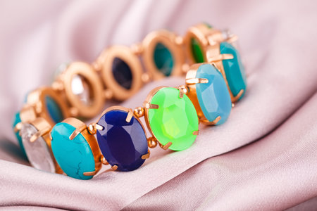 Stylish bracelet with colorful stones on fabric background.の写真素材