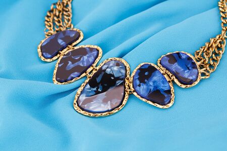 Stylish necklace on blue fabric background.の写真素材