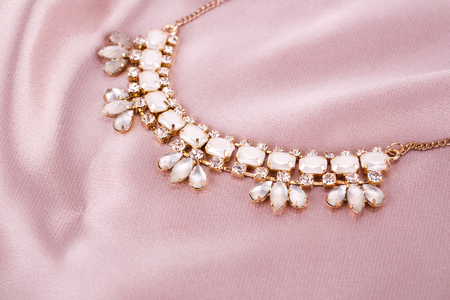 Stylish necklace with stones on pink fabric background.の写真素材