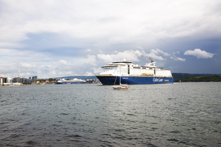 Oslo, Norway-August 13, 2014 - Coastline with cruise liner with people on it.のeditorial素材