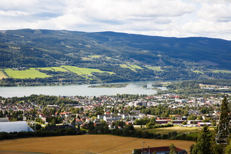 Landscape with mountains, river and buildings in Lillehammer town, Norway.