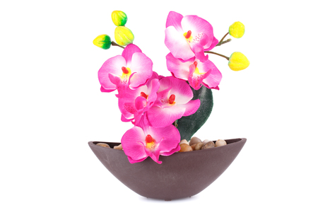 Pink artificial orchid in vase isolated on white background.の写真素材