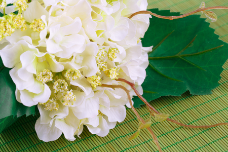 White fabric flowers on bamboo background, closeup picture.の写真素材