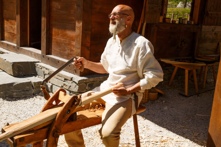 Gudvangen, Norway - June 13 - The man carpenter in national clothes in the viking village museum.