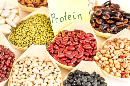 The collection of different beans in the bamboo bowls with the notice protein on paper.の写真素材